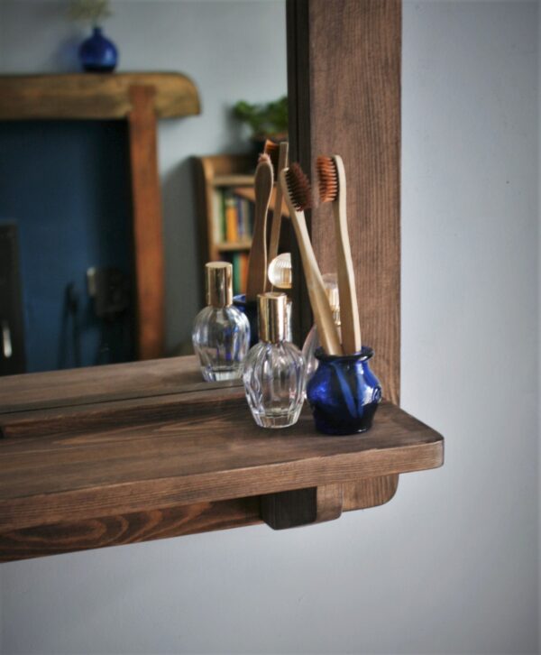 Wooden mirror with candle shelf in portrait, close up of shelf.
