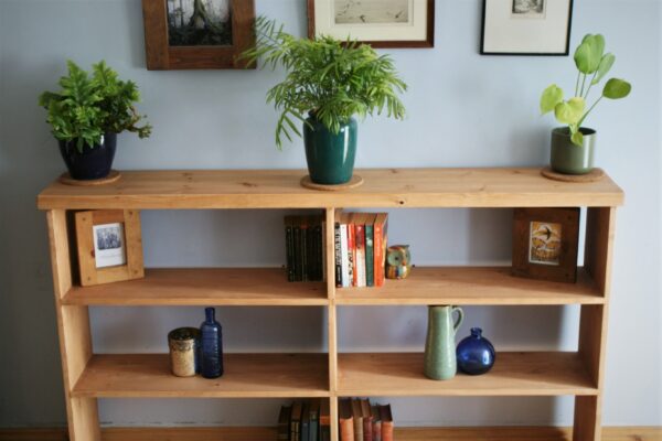 Wide wooden bookshelves in chunky rustic natural wood, handmade in Somerset UK. Top close up view.