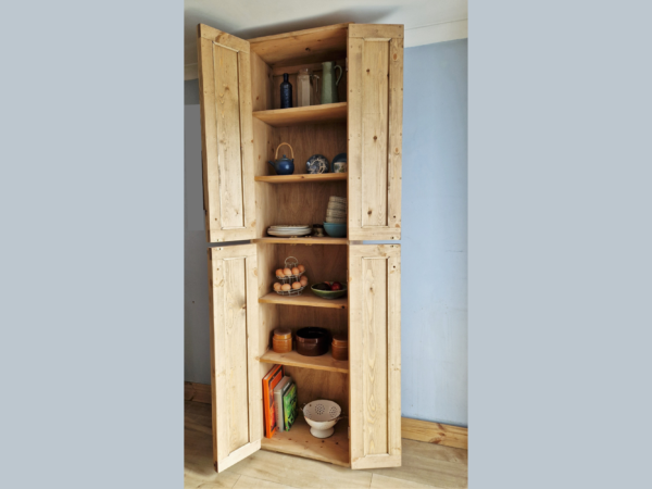 Tall kitchen larder pantry cabinet in natural wood with 2 sets of doors wide open.
