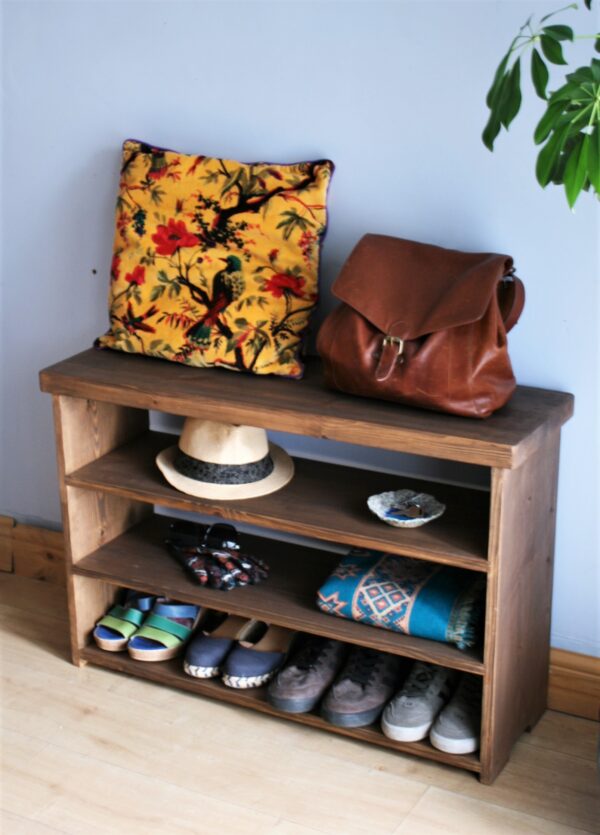 Rustic shoe rack bench and hall table in natural wood, with handbag, close up.