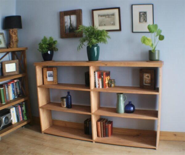 Wide wooden bookshelves in chunky rustic natural wood, handmade in Somerset UK. Long view.