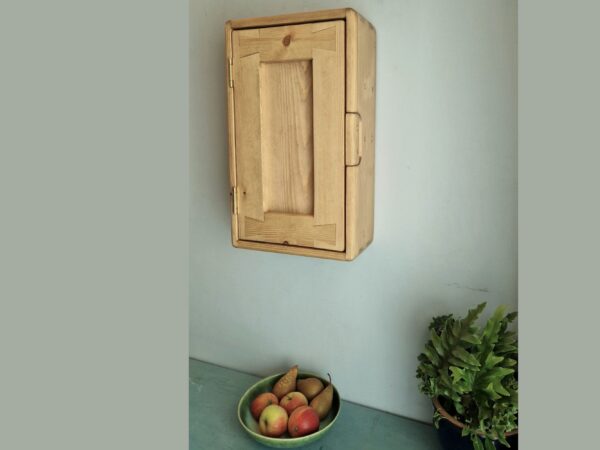 Kitchen wall cabinet, slim wooden storage cupboard for narrow space with fruit bowl on the counter beneath.