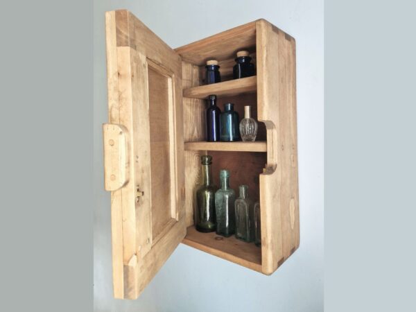 Slim bathroom mirror cabinet in natural rustic wood. Handmade in UK, seen with the chunky door open and cosmetics on display.