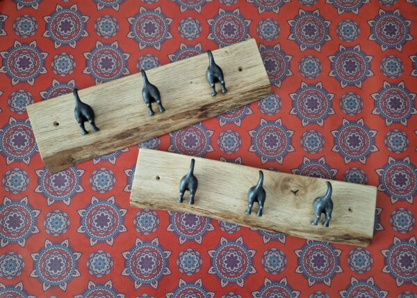 Live edge coat rack with 3 ‘waggy dog tails’ cast iron hooks on a chunky natural Oak plaque, boho wallpaper.